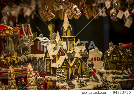 Advent Bazaar Stalls with glass, wooden, ceramic christmas souvenirs in shops. Close up of festive decorations for tree in winter street night market during new year's holiday. Illuminated fair kiosk Advent Bazaar Stalls with glass, wooden, ceramic christmas souvenirs in shops. Close up of festive decorations for tree in winter street night market during new year's holiday. Illuminated fair kiosk 94823730