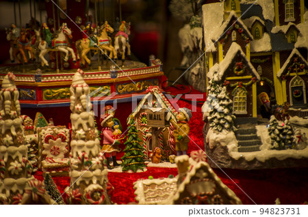 Advent Bazaar Stalls with glass, wooden, ceramic christmas souvenirs in shops. Close up of festive decorations for tree in winter street night market during new year's holiday. Illuminated fair kiosk 94823731