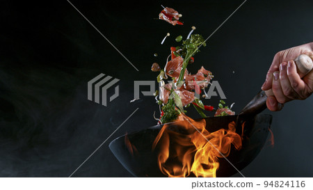 Freeze Motion of Wok Pan with Flying Ingredients in the Air and Fire Flames. Freeze Motion of Wok Pan with Flying Ingredients in the Air and Fire Flames. 94824116