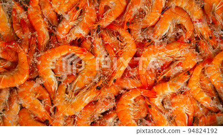 Falling prawns into water, black background, top shot 94824192