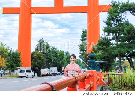 在大鳥居前享受京都觀光的和服女子 94824479