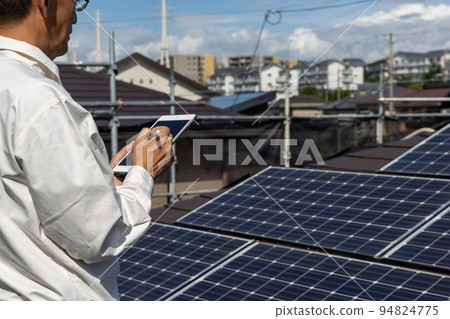 A man inspecting a solar power system A man inspecting a solar power system 94824775