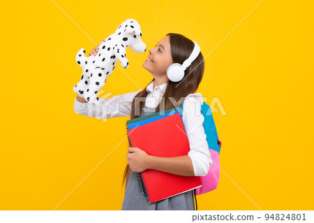 School teenager child girl with book and backpack hold toy. Fun study. Education and childhood concept. Happy schoolgirl, positive and smiling kids. School teenager child girl with book and backpack hold toy. Fun study. Education and childhood concept. Happy schoolgirl, positive and smiling kids. 94824801