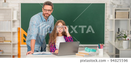 Father and daughter at school, teacher and pupil banner. amazed father and child study at school with laptop on blackboard background, e-learning 94825596