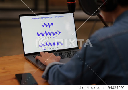 Podcaster editing audio podcast working at home studio 94825691
