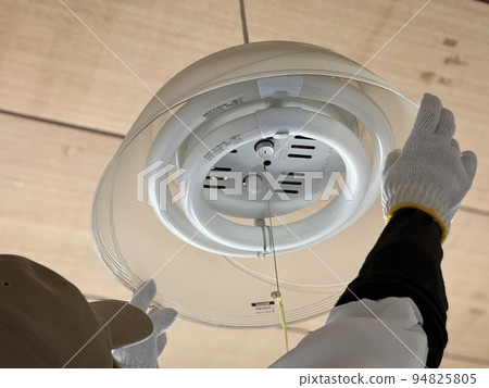Hand wearing a hat and replacing the round fluorescent lamp Hand wearing a hat and replacing the round fluorescent lamp 94825805