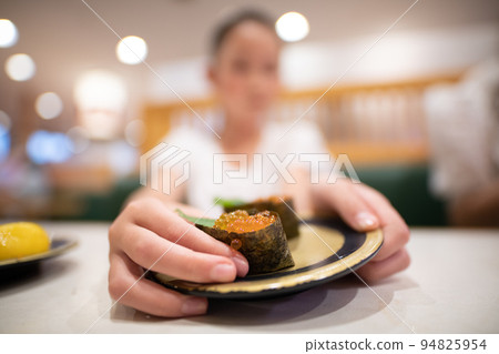 kid eating sushi 94825954