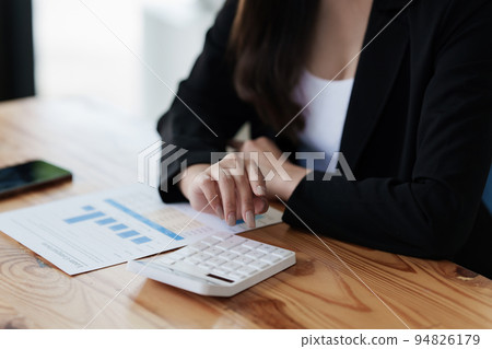 Asian Business Woman or Accountant do math and analyze with calculator and paperwork on desk, account, audit and saving concept Asian Business Woman or Accountant do math and analyze with calculator and paperwork on desk, account, audit and saving concept 94826179