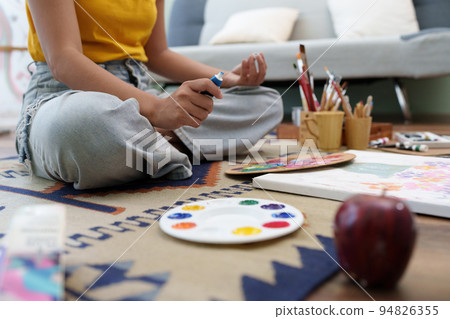 Joyful young female artist painting on canvas at workshop Joyful young female artist painting on canvas at workshop 94826355