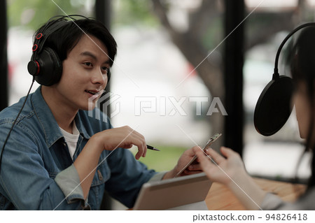 Asian podcaster making audio podcast working with guest at home studio Asian podcaster making audio podcast working with guest at home studio 94826418
