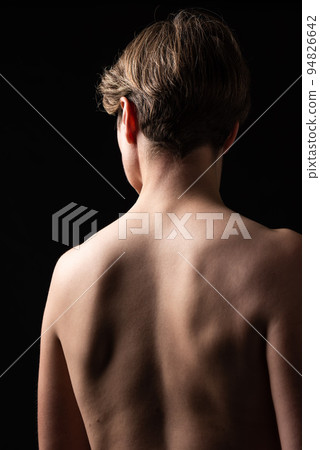 Thirty year old woman with naked back in a studio portrait Thirty year old woman with naked back in a studio portrait 94826642