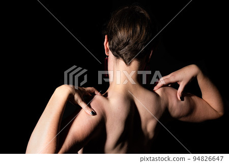 Thirty year old woman with naked torso, showing her muscles in a studio portrait 94826647