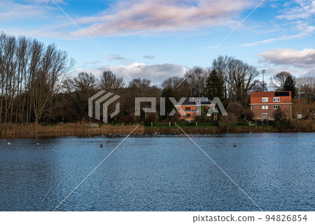 Anderlecht, Brussels Capital Region - Belgium - Two holiday houses at the lake of the Pede park with a colorful winter sky Anderlecht, Brussels Capital Region - Belgium - Two holiday houses at the lake of the Pede park with a colorful winter sky 94826854