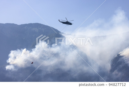 Wildfire Service Helicopter flying over BC Forest Fire and Smoke on the mountain near Hope Wildfire Service Helicopter flying over BC Forest Fire and Smoke on the mountain near Hope 94827712