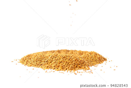 Crumbled bee pollen granules on white background. Crumbled bee pollen granules on white background. 94828543
