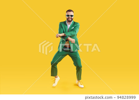 Cheerful and stylish man is having fun dancing in Gangnam style at St. Patrick's Day party. Cheerful and stylish man is having fun dancing in Gangnam style at St. Patrick's Day party. 94828999