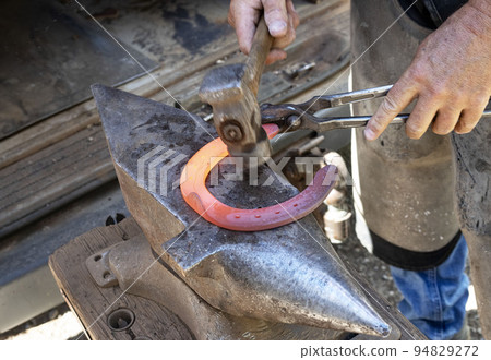 Farrier works in a field Farrier works in a field 94829272