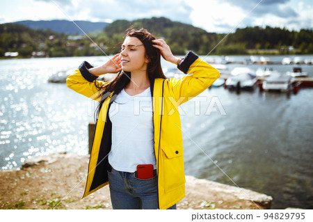 Young woman enjoys freedom against the backdrop of the mountains in the Norway. The girl tourist. 94829795