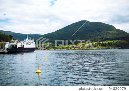 A ship sailing in Norwegian fjords. Amazing nature view with fjord and mountains. Beautiful reflection. 94829979