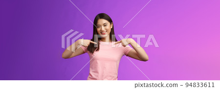 Active energized friendly tender asian stylish girl introduce herself, pointing chest proudly, smiling boastful, describe own achievements, bragging accomplishments, stand pleased purple background 94833611
