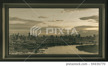 Skyscrapers along Chao phraya river in the evening time. Seen through a bedroom window frame. The beautiful view of Bangkok city, 94836770