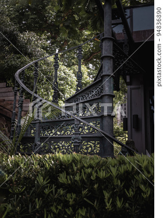 Black metal spiral staircase pattern with iron railing lead from the ground floor to the upper floor. 94836890