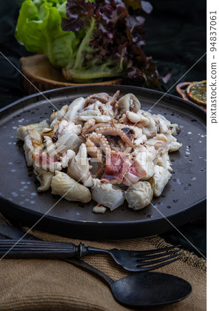 Close-up of Fresh grilled squid, Octopus tentacles and Squids eggs on Ceramic plate. Close-up of Fresh grilled squid, Octopus tentacles and Squids eggs on Ceramic plate. 94837061