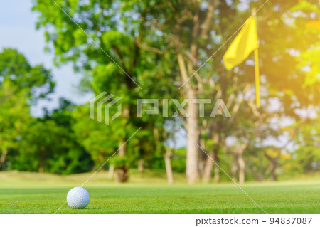 Golf ball on green grass ready to be struck on golf course Golf ball on green grass ready to be struck on golf course 94837087