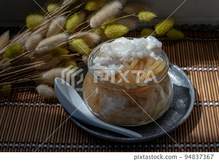 Kanom pla krim khai tao or Sweet rice noodles with coconut cream in glass bowl served with white spoon. Kanom pla krim khai tao or Sweet rice noodles with coconut cream in glass bowl served with white spoon. 94837367