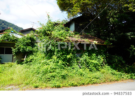 An abandoned house overgrown with grass and crumbling | Social problem 94837583