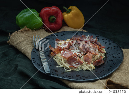 Truffle carbonara spaghetti with fried bacon and grated cheese in ceramic plate. 94838250