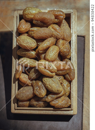 Terminalia bellerica or Terminalia chebula (Organic dry harad). Dried fruits in the wooden box. Terminalia bellerica or Terminalia chebula (Organic dry harad). Dried fruits in the wooden box. 94838422