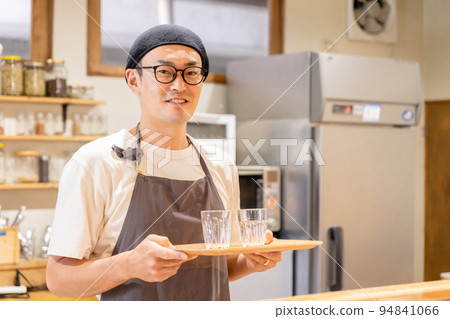 男性咖啡館工作人員在咖啡館廚房裡拿著水 94841066