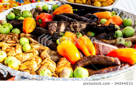 Appetizing baked meat, sausage and vegetables in a frying pan Appetizing baked meat, sausage and vegetables in a frying pan 94844810
