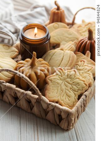 Cookies shaped like pumpkin and leaves on rustic wood background 94844824