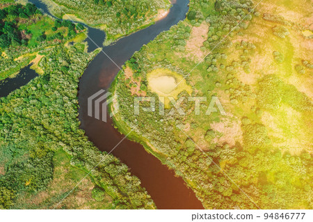 Bird's Eye View Of Green Forest Woods In Sunny Day. Aerial View Of Summer Curved River Landscape. Top View Of Beautiful European Nature From High Attitude. Drone Flight View Bird's Eye View Of Green Forest Woods In Sunny Day. Aerial View Of Summer Curved River Landscape. Top View Of Beautiful European Nature From High Attitude. Drone Flight View 94846777