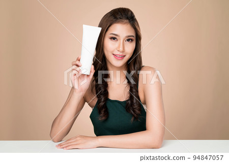 Ardent woman smiling holding mockup product for advertising text place. 94847057