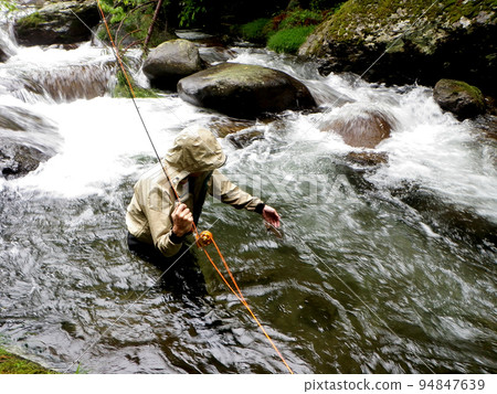 用飛釣在雨中逆流垂釣 94847639