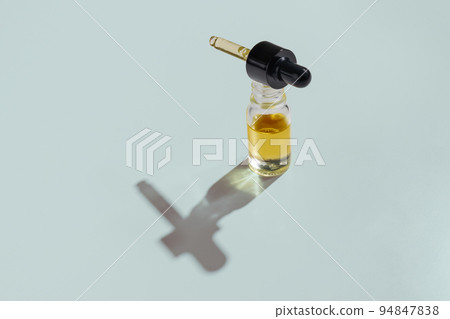 Legalized CBD oil in clear, glass container with dropper lid isolated background Legalized CBD oil in clear, glass container with dropper lid isolated background 94847838