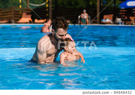 Father teach baby to swim in pool Father teach baby to swim in pool 94848432
