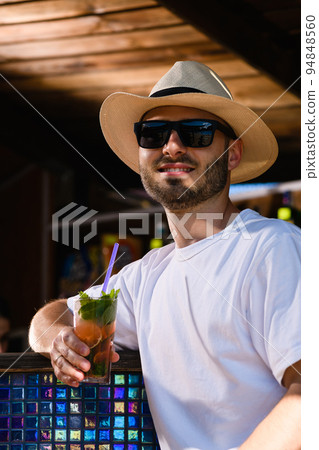 Young man drink cocktail in beach bar Young man drink cocktail in beach bar 94848560