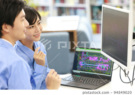 A female designer receiving an explanation of CAD design from a senior employee_3 94849020