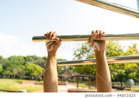 在公園的健康遊樂場設備上伸展的女人的手 在公園的健康遊樂場設備上伸展的女人的手 94851025
