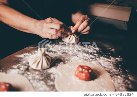 Chef of a Georgian restaurant sculpts khinkali. Khinkali cooking process.. 94852824