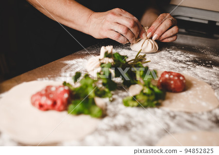Chef of a Georgian restaurant sculpts khinkali. Khinkali cooking process.. 94852825