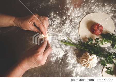 The cook sculpts khinkali according to the original Georgian recipe. The cook sculpts khinkali according to the original Georgian recipe. 94852828