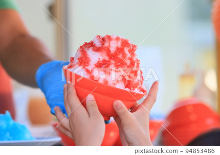 Large serving of shaved ice Shaved ice with plenty of strawberry syrup 94853486