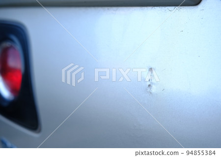 Scratched back bumper on the grey metallic car. Closeup image of damaged back bumper on the car. Photo for the insurance company of a scratched car. Scratched back bumper on the grey metallic car. Closeup image of damaged back bumper on the car. Photo for the insurance company of a scratched car. 94855384
