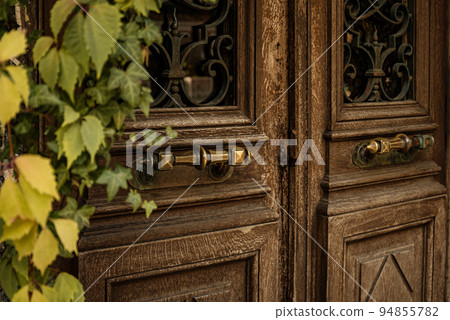 weathered and scratched old wooden door with metal handles close up 94855782