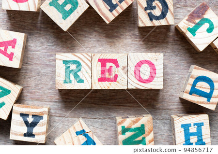 Alphabet letter block in word REO (Abbreviation of Real estate owned) and another letter on wood background 94856717